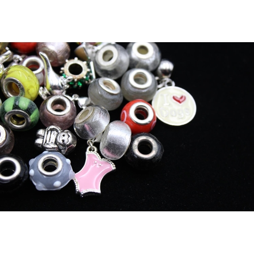 117 - A large collection of bracelet charms, some stamped .925 silver