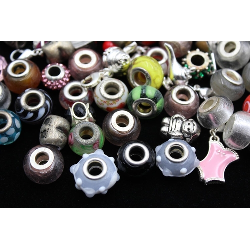 117 - A large collection of bracelet charms, some stamped .925 silver