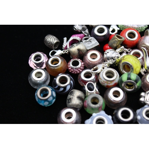 117 - A large collection of bracelet charms, some stamped .925 silver
