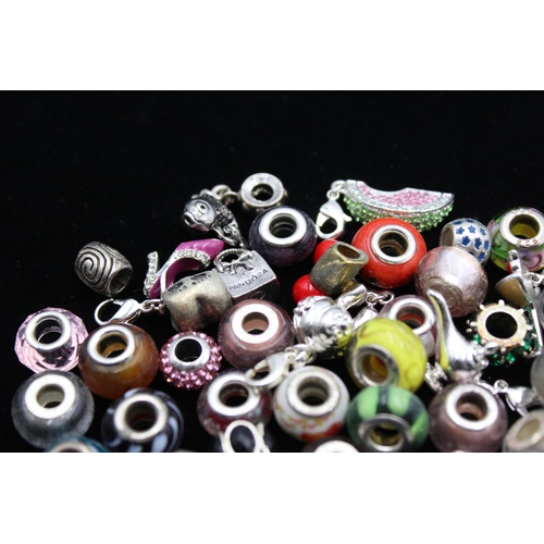 117 - A large collection of bracelet charms, some stamped .925 silver