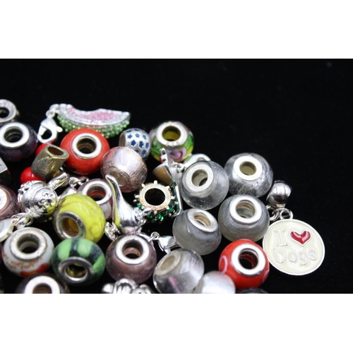 117 - A large collection of bracelet charms, some stamped .925 silver