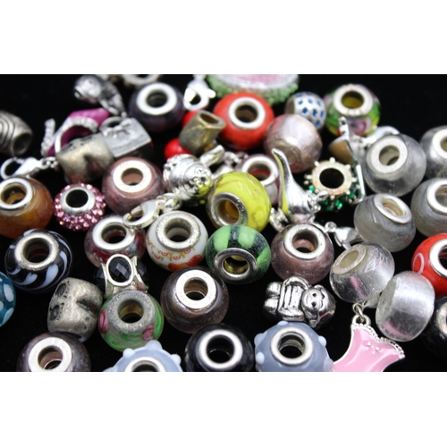 117 - A large collection of bracelet charms, some stamped .925 silver