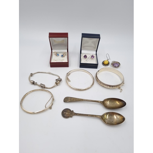 101 - A collection of .925 silver and white metal items to include three .925 silver bangles, Pandora char... 