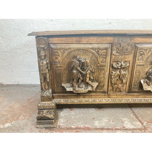 1034 - A reproduction Roman style heavily carved wooden blanket box/chest - approx. 70cm high x 136cm wide ... 