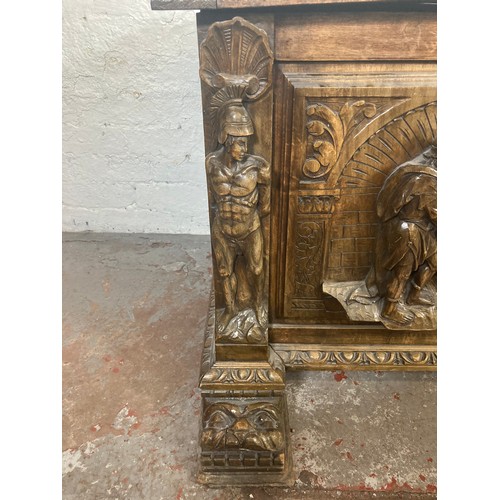 1034 - A reproduction Roman style heavily carved wooden blanket box/chest - approx. 70cm high x 136cm wide ... 