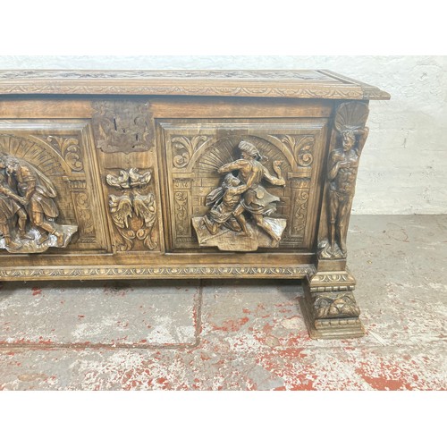 1034 - A reproduction Roman style heavily carved wooden blanket box/chest - approx. 70cm high x 136cm wide ... 