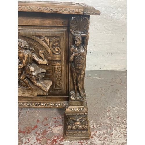 1034 - A reproduction Roman style heavily carved wooden blanket box/chest - approx. 70cm high x 136cm wide ... 