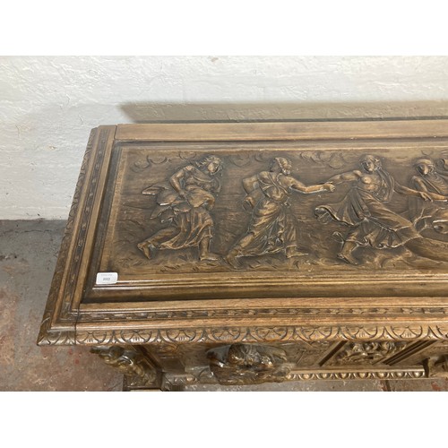 1034 - A reproduction Roman style heavily carved wooden blanket box/chest - approx. 70cm high x 136cm wide ... 