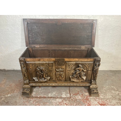 1034 - A reproduction Roman style heavily carved wooden blanket box/chest - approx. 70cm high x 136cm wide ... 