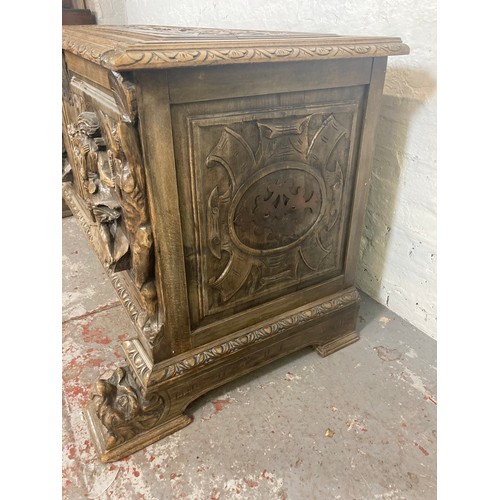 1034 - A reproduction Roman style heavily carved wooden blanket box/chest - approx. 70cm high x 136cm wide ... 