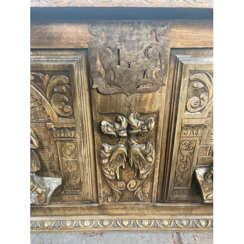 1034 - A reproduction Roman style heavily carved wooden blanket box/chest - approx. 70cm high x 136cm wide ... 