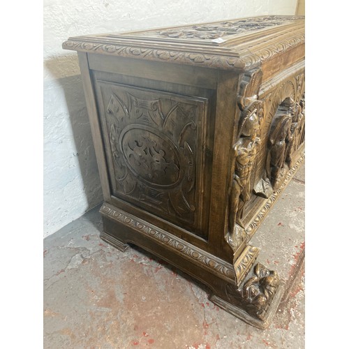 1034 - A reproduction Roman style heavily carved wooden blanket box/chest - approx. 70cm high x 136cm wide ... 