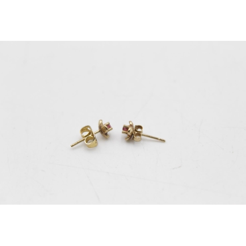 107 - Three pairs of 9ct gold gemstone stud earrings, one opal and two ruby - approx. gross weight 1.8 gra... 