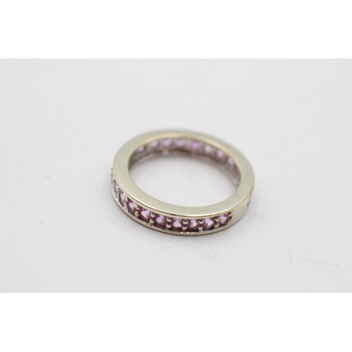 140 - A 9ct white gold pink sapphire eternity ring, size M½ - approx. gross weight 3.6 grams