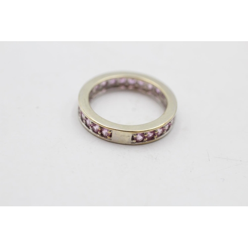 140 - A 9ct white gold pink sapphire eternity ring, size M½ - approx. gross weight 3.6 grams