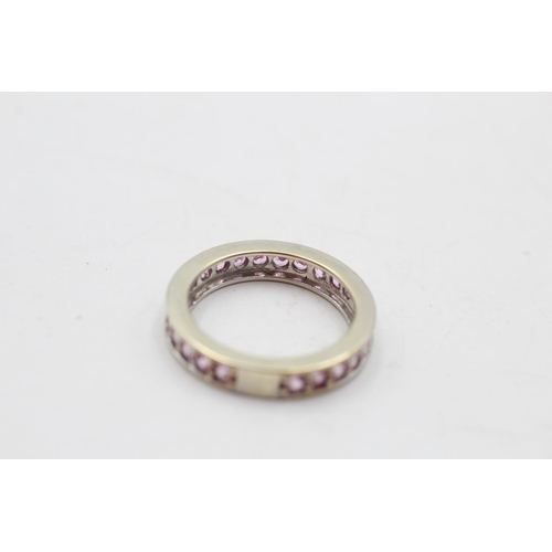 140 - A 9ct white gold pink sapphire eternity ring, size M½ - approx. gross weight 3.6 grams