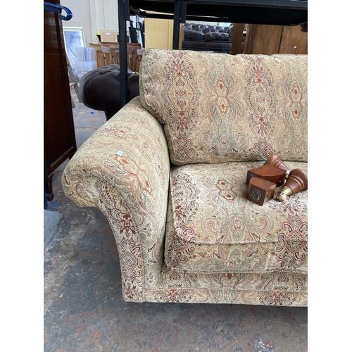 1166 - A Parker Knoll upholstered two seater sofa with brass castors