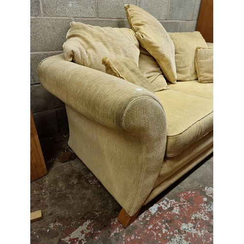 1197 - A modern cream upholstered two seater sofa