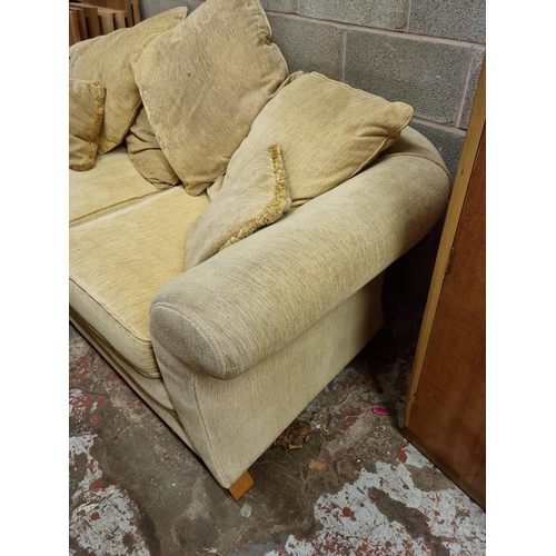 1197 - A modern cream upholstered two seater sofa