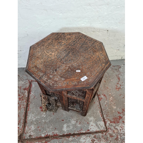 1037 - An Indian heavily carved teak octagonal top side table