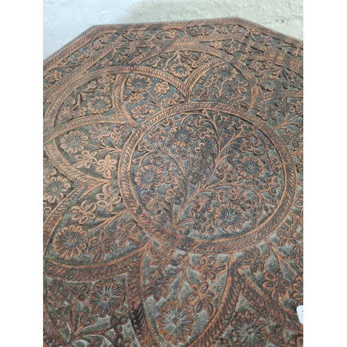 1037 - An Indian heavily carved teak octagonal top side table