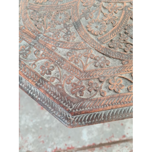 1037 - An Indian heavily carved teak octagonal top side table