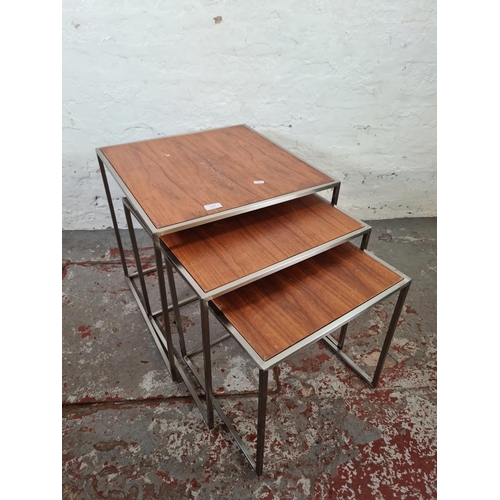 1077 - A teak and metal nest of three tables