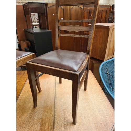 1097 - An early/mid 20th century oak drop leaf gate leg dining table with six matching oak and brown leathe... 