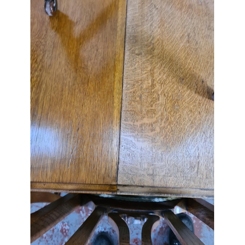 1142 - An Art Nouveau oak wind out extending dining table with six matching chairs and winder - approx. 77c... 