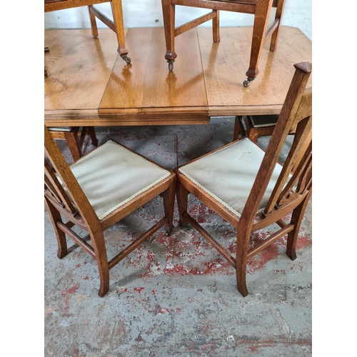 1142 - An Art Nouveau oak wind out extending dining table with six matching chairs and winder - approx. 77c... 