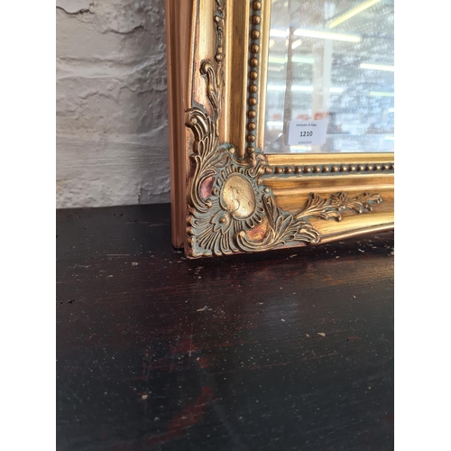 1210 - A gilt framed bevelled edge mirror - approx. 105cm wide x 75cm high