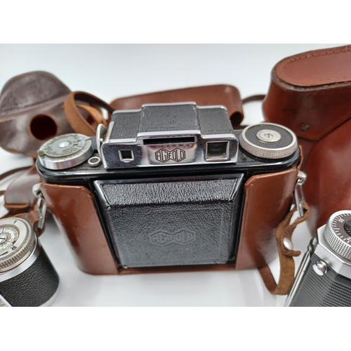 1264 - A collection of camera equipment to include cased Praktica VF 35mm SLR, cased Agilux Agifold folding... 