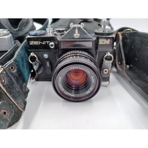 1269 - Four cased vintage 35mm SLR cameras, one part cased Zenit EM fitted with Pentacon auto 1.8/50 lens, ... 