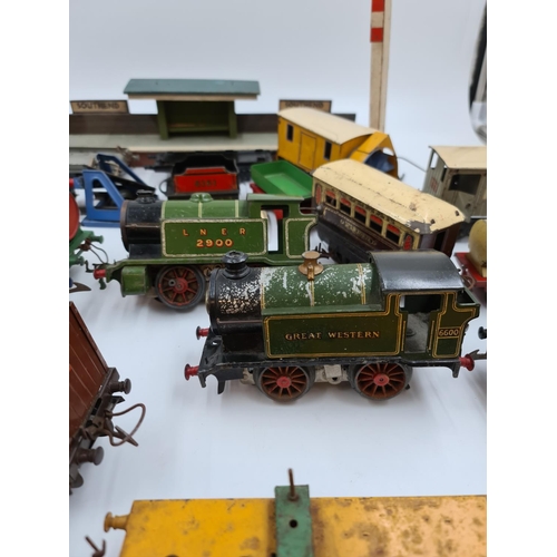 593 - A collection of vintage Hornby tinplate model railway accessories to include trains, tankers etc.