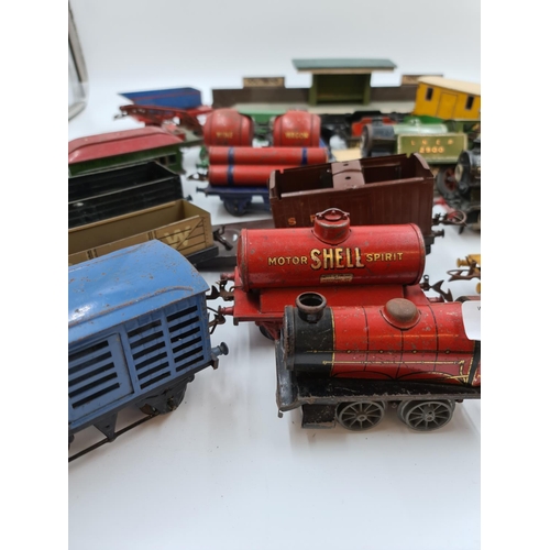 593 - A collection of vintage Hornby tinplate model railway accessories to include trains, tankers etc.