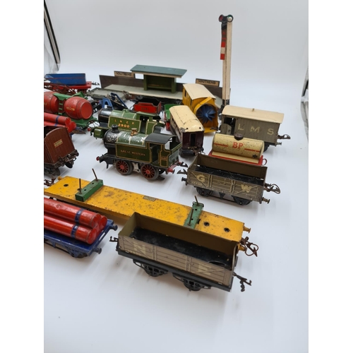 593 - A collection of vintage Hornby tinplate model railway accessories to include trains, tankers etc.