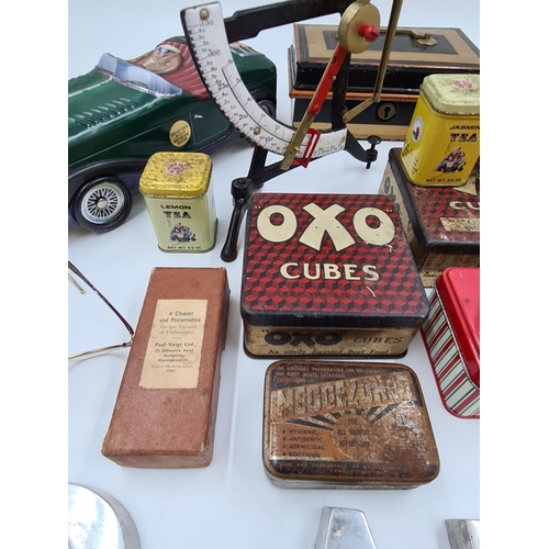 517 - A collection of assorted items to include vintage novelty tins, early 20th century postal scale etc.