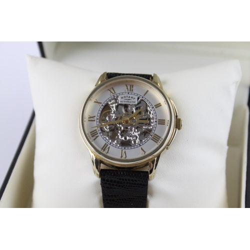 262 - A boxed gents Rotary quality gold tone automatic wristwatch with skeletonised movement and black liz... 