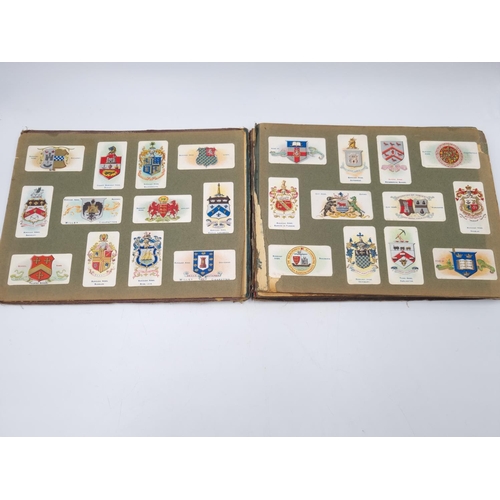 305 - An antique Wills's cigarette card album containing heraldic cigarette cards to include Borough Arms ... 