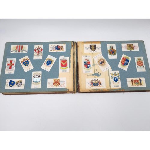 305 - An antique Wills's cigarette card album containing heraldic cigarette cards to include Borough Arms ... 