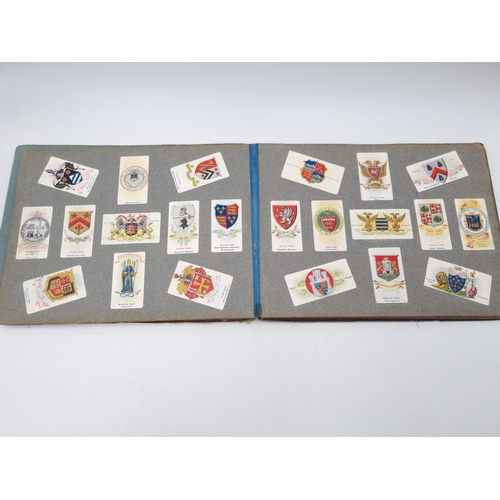 305 - An antique Wills's cigarette card album containing heraldic cigarette cards to include Borough Arms ... 