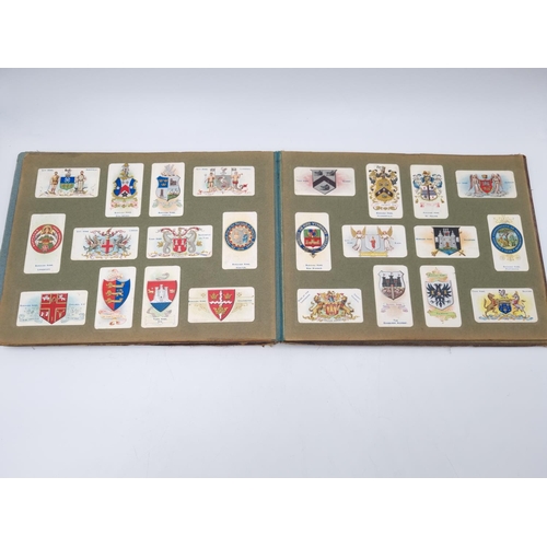 305 - An antique Wills's cigarette card album containing heraldic cigarette cards to include Borough Arms ... 