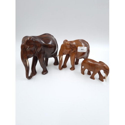 655 - A collection of treenware, three carved hardwood elephant figurines, one carved hardwood rhino figur... 