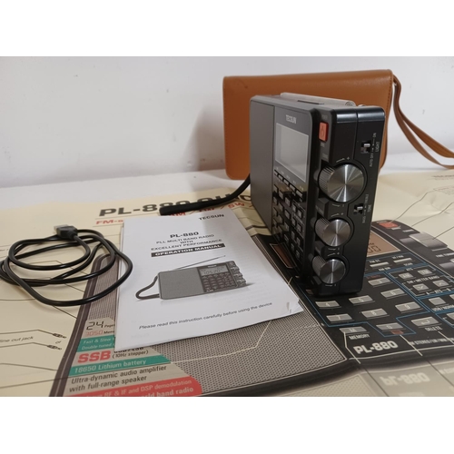 1304 - A cased Tecsun PL-880 multi band radio with instruction manual and radio world map amateur