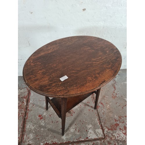 1193D - An early 20th century oak oval top two tier side table - approx. 71cm high x 45cm wide x 62cm long