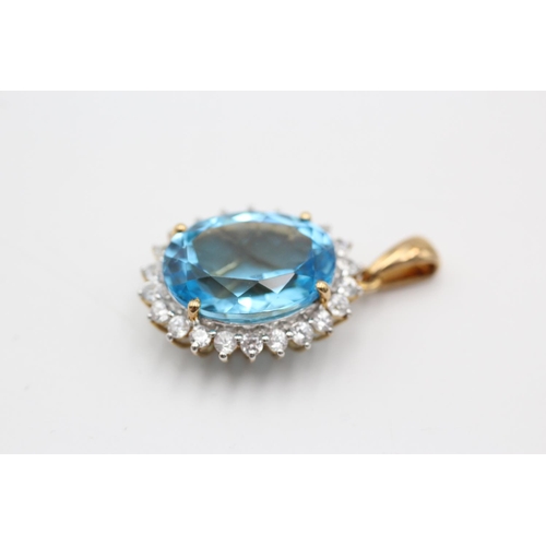11 - A 9ct gold blue topaz and clear gemstone halo pendant - approx. gross weight 4.7 grams
