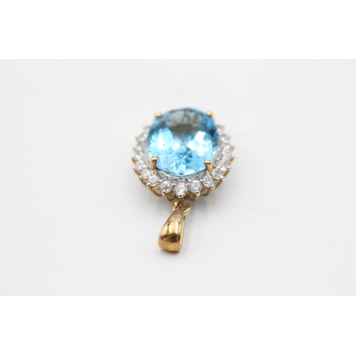 11 - A 9ct gold blue topaz and clear gemstone halo pendant - approx. gross weight 4.7 grams