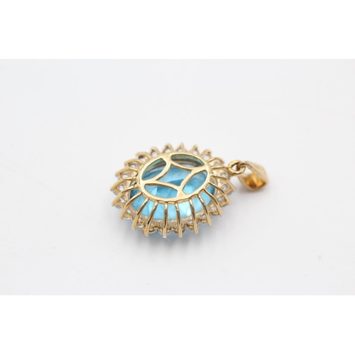 11 - A 9ct gold blue topaz and clear gemstone halo pendant - approx. gross weight 4.7 grams