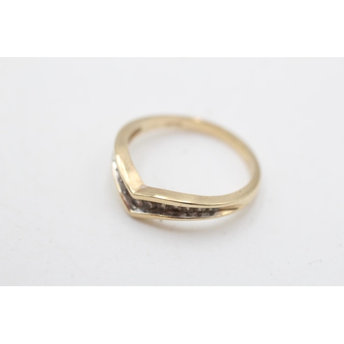 27 - A 9ct gold diamond channel set wishbone ring, size O½ - approx. gross weight 2.3 grams