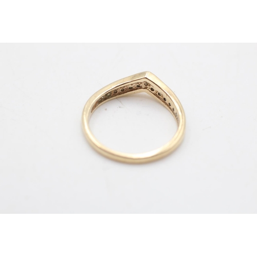 27 - A 9ct gold diamond channel set wishbone ring, size O½ - approx. gross weight 2.3 grams